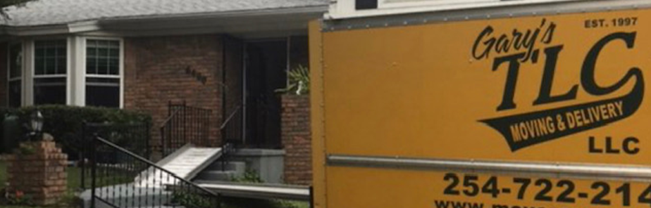 Gary's TLC Moving & Delivery truck parked in front of brick residential home
