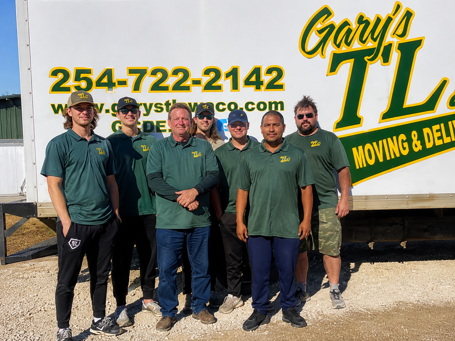 Gary's TLC moving company team of seven workers posing in front of branded truck